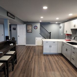 A kitchen with wooden floors and white cabinets