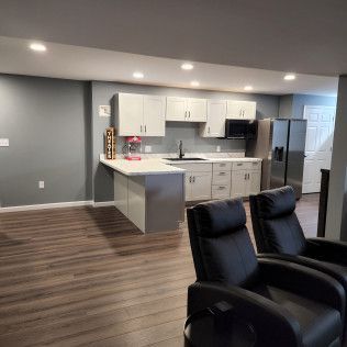 A kitchen with two chairs and a refrigerator