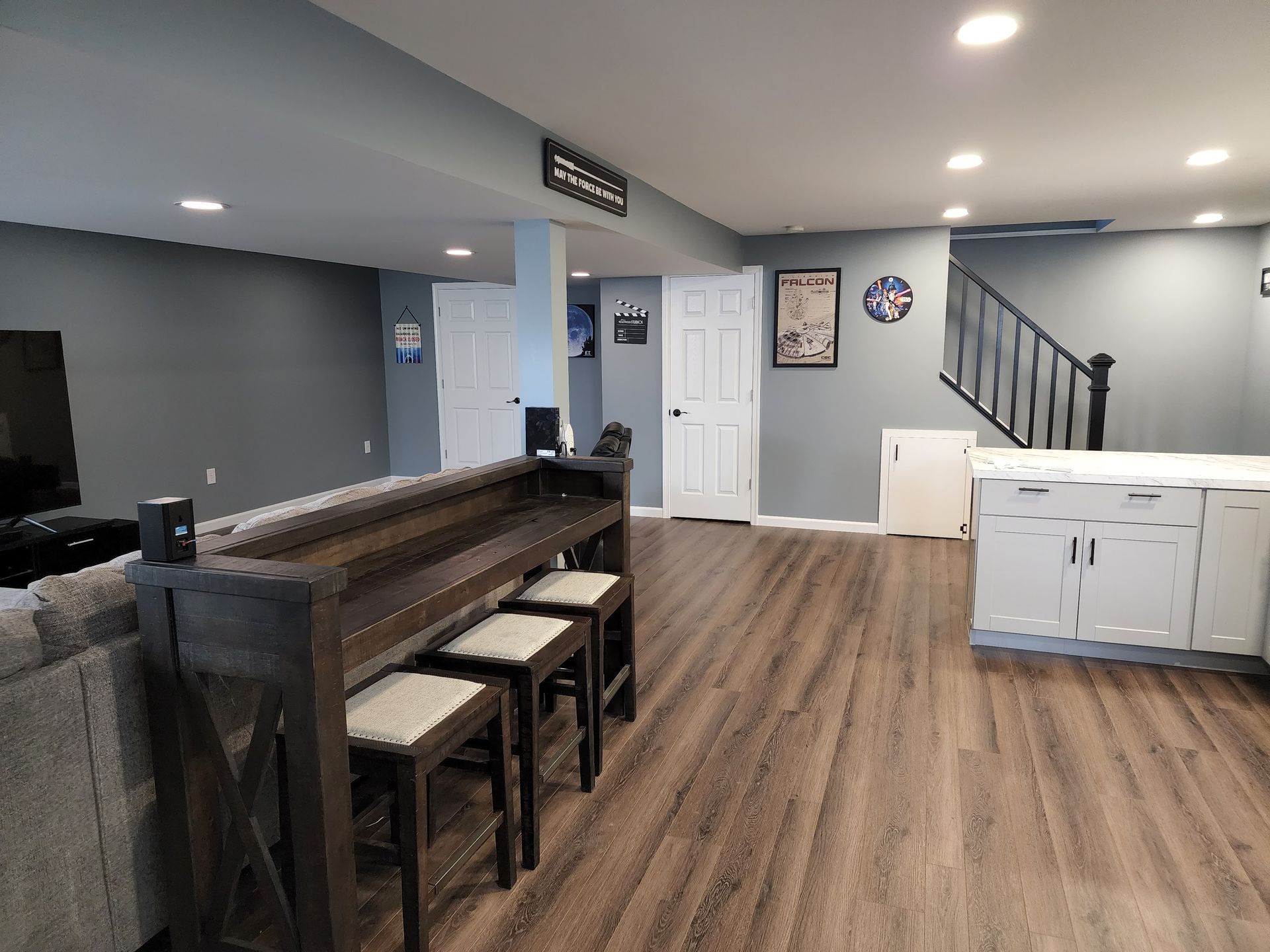 A living room with hardwood floors , a couch , a table and stools.