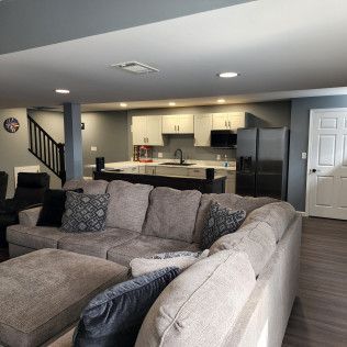 A living room with a large sectional couch and ottoman