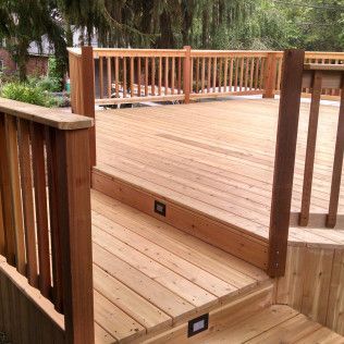A wooden deck with stairs and a wooden railing
