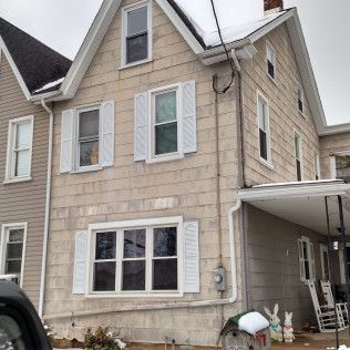 A house with white shutters and a mailbox in front of it