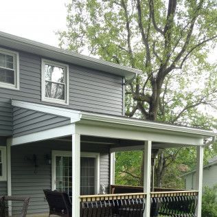 A house with a porch and a tree in the background