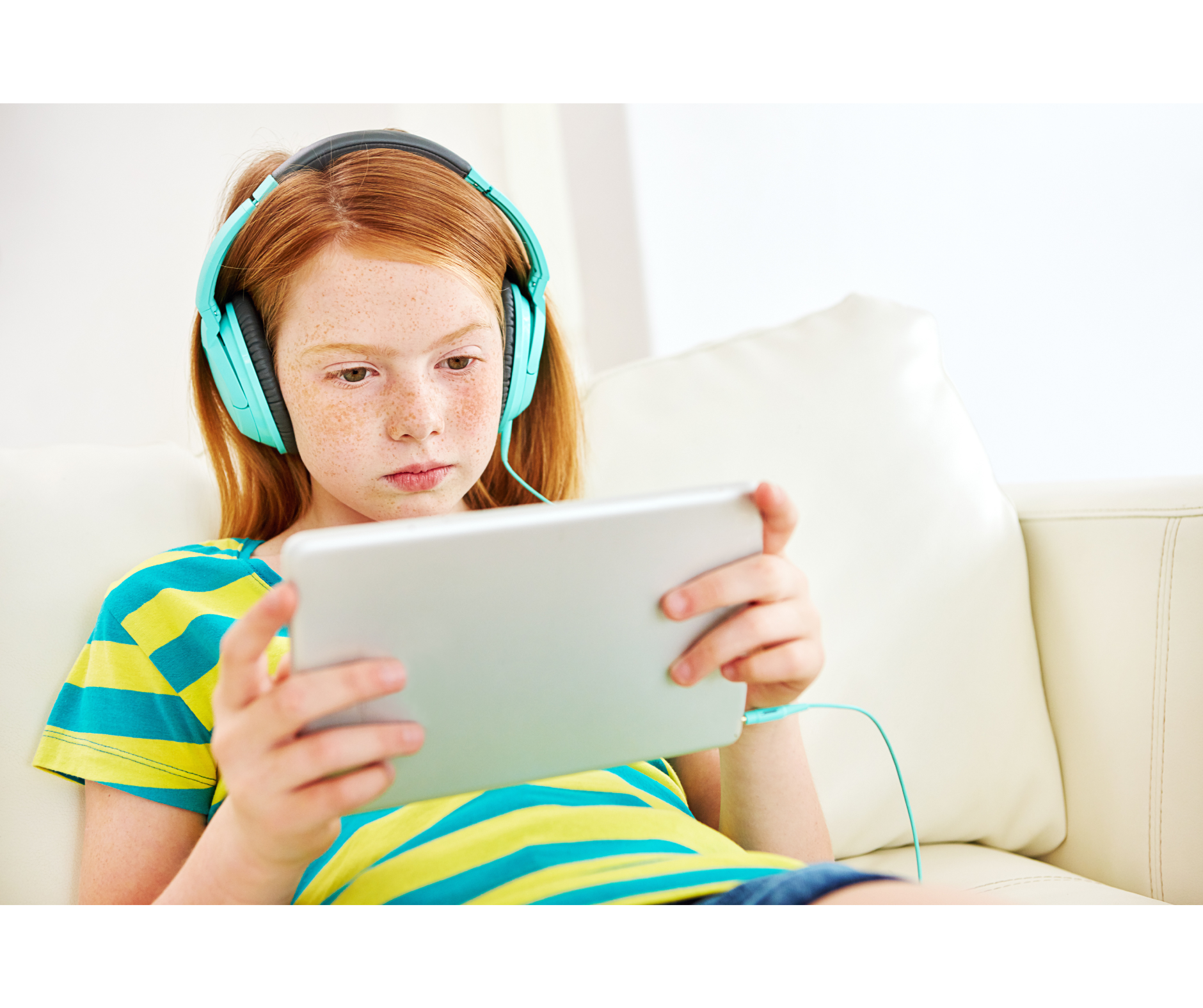 A young girl wearing headphones is using a tablet computer.