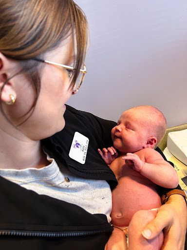 A woman is holding a newborn baby in her arms.