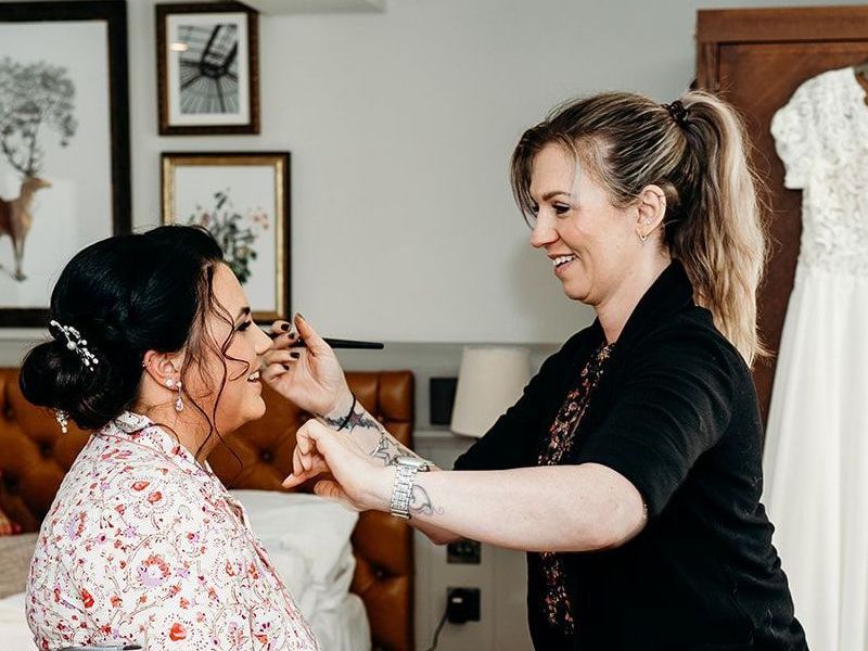 Jax applying natural bridal makeup on a bride during her wedding morning