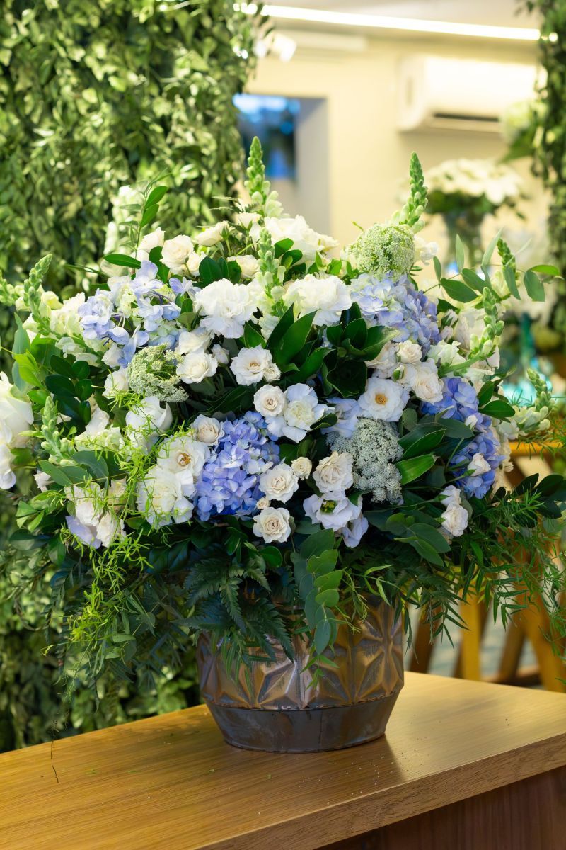 Blue and white flower arrangement in a clear vase on a wooden table