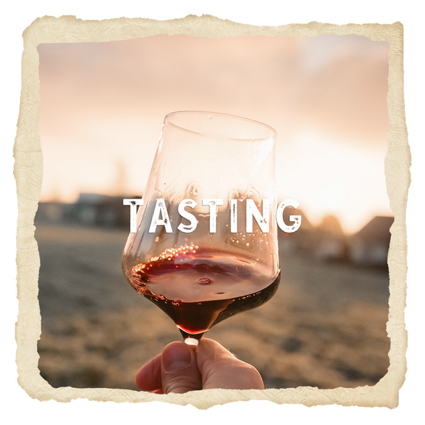 A person is holding a glass of wine with the word tasting written on it