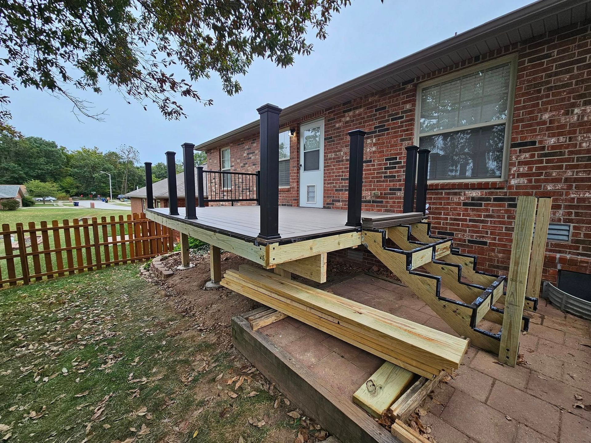 Dilapidated wooden ramp and steps beside a brick house porch