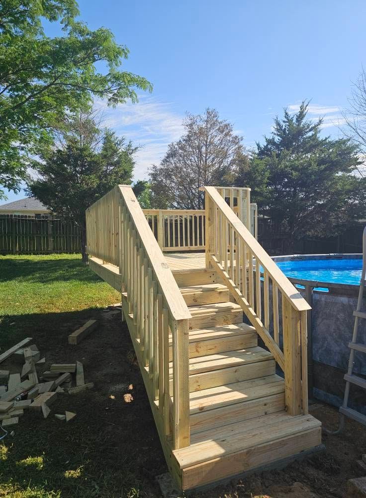 Wooden backyard stairs with railings beside a pool, newly built in a sunny yard