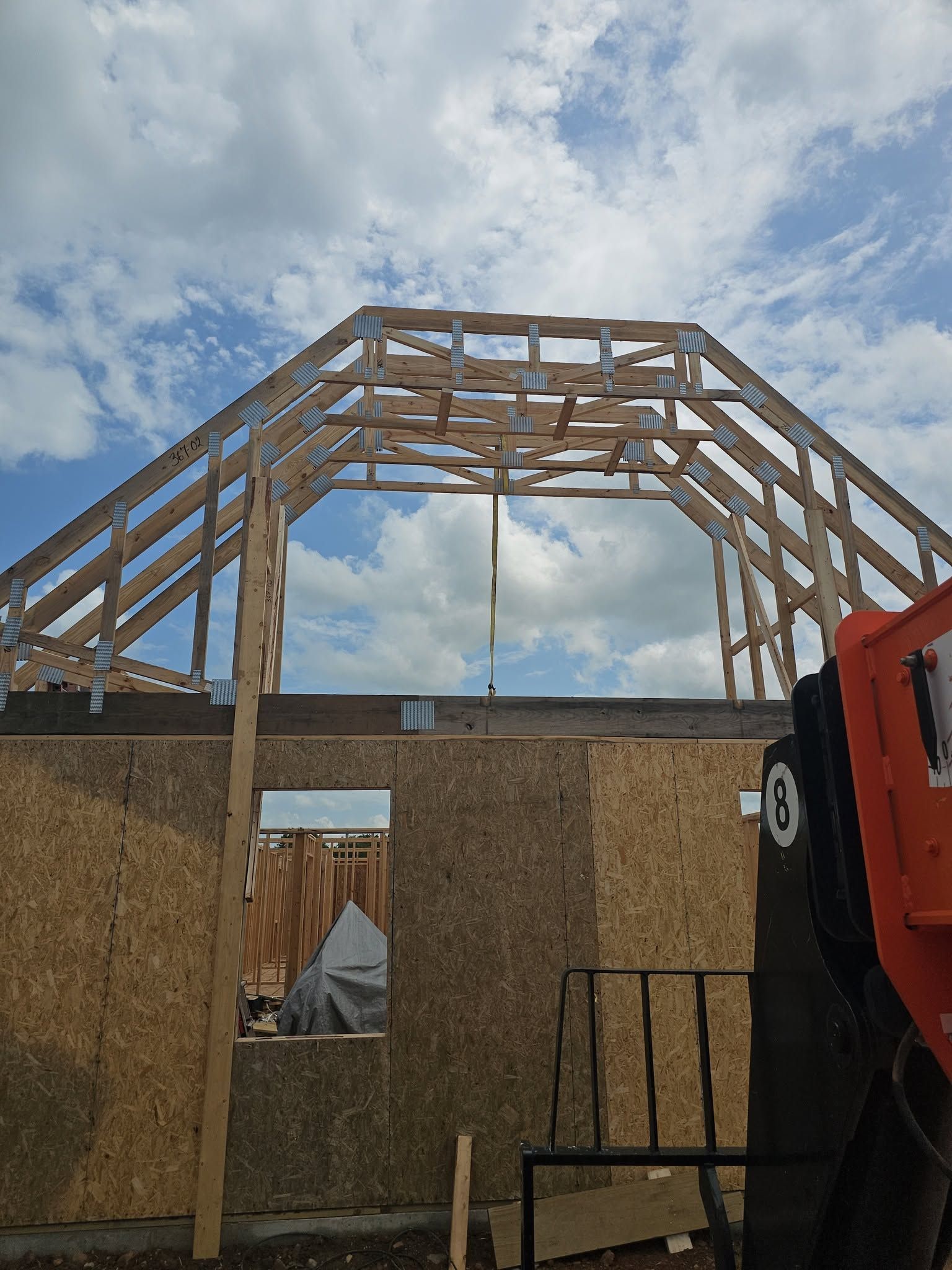 Partially framed building roof under construction against a cloudy sky