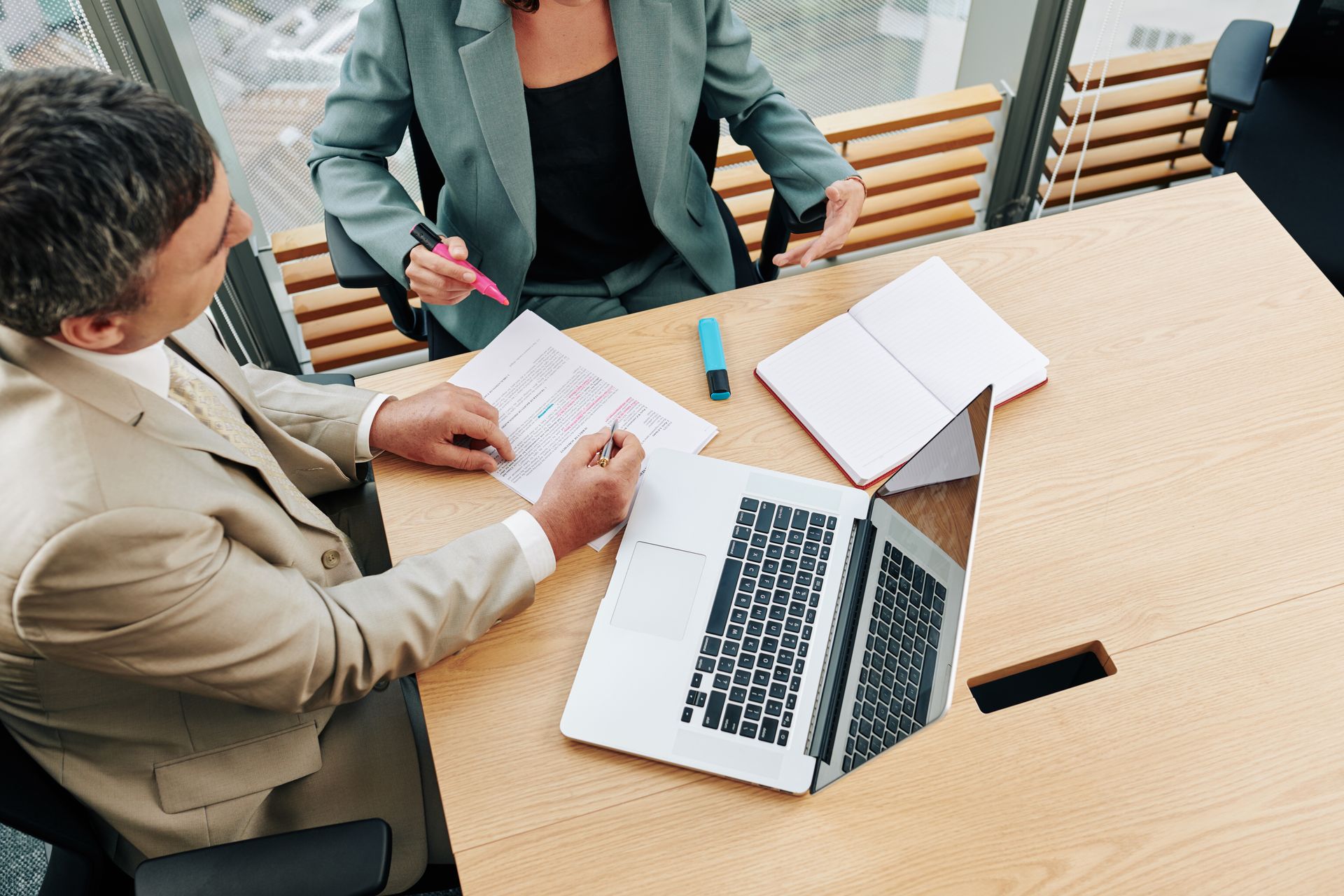 A man and a woman are sitting at a table with a laptop.