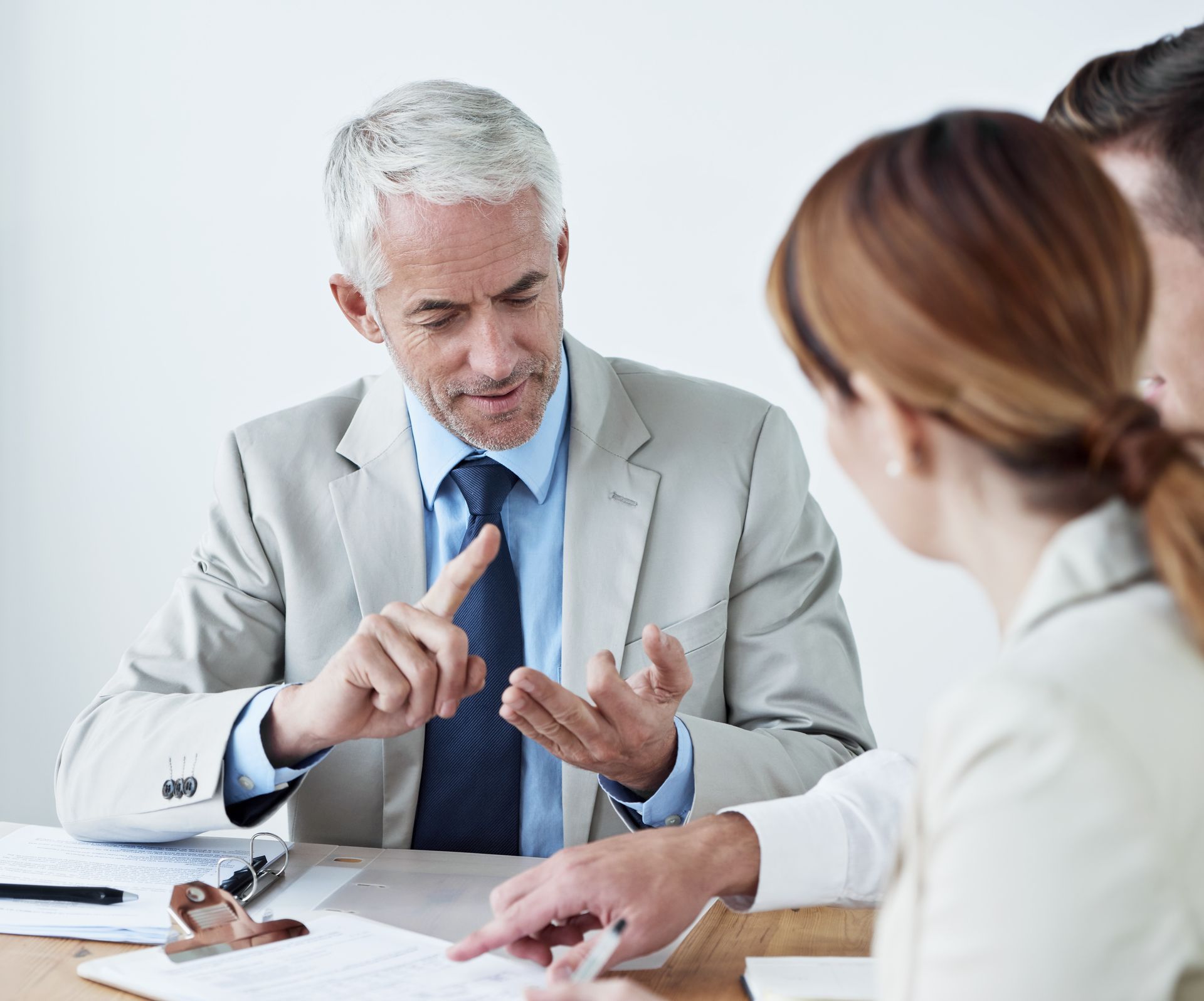 A man in a suit and tie is talking to a group of people