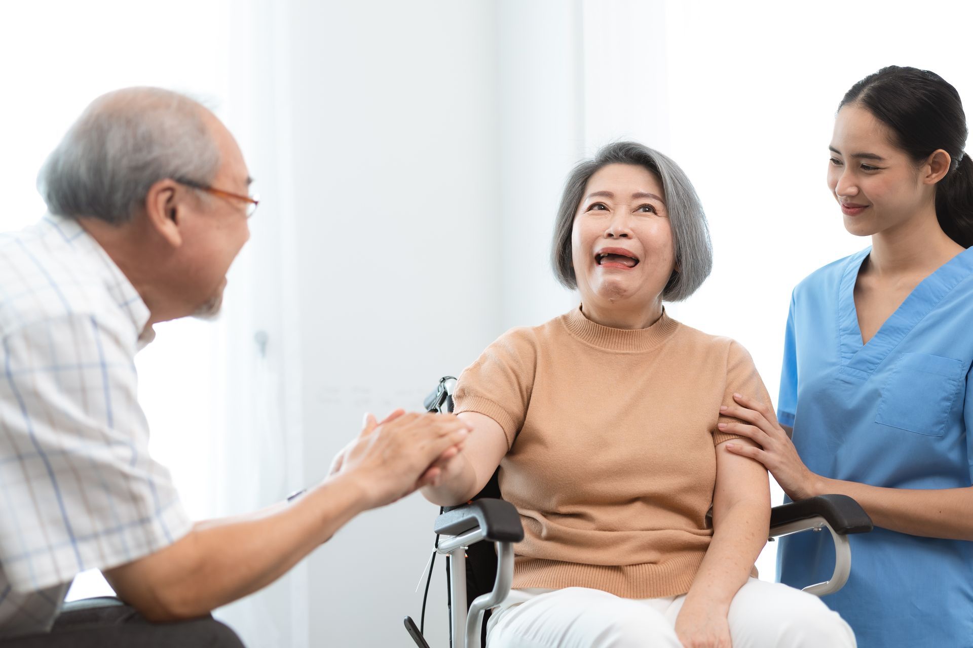 A man is talking to an elderly woman in a wheelchair.