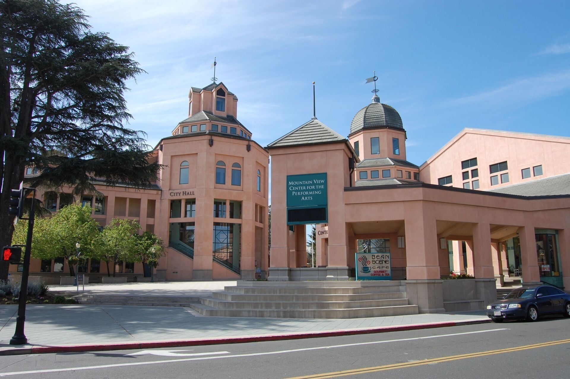 A large pink building with a cross on top of it