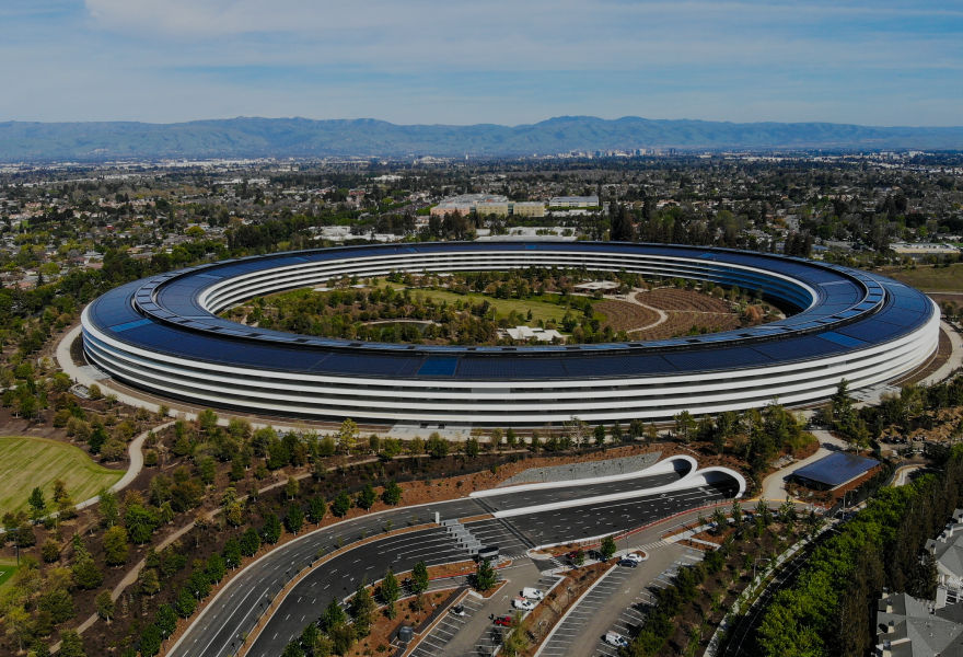An aerial view of a large building with a lot of solar panels on the roof.