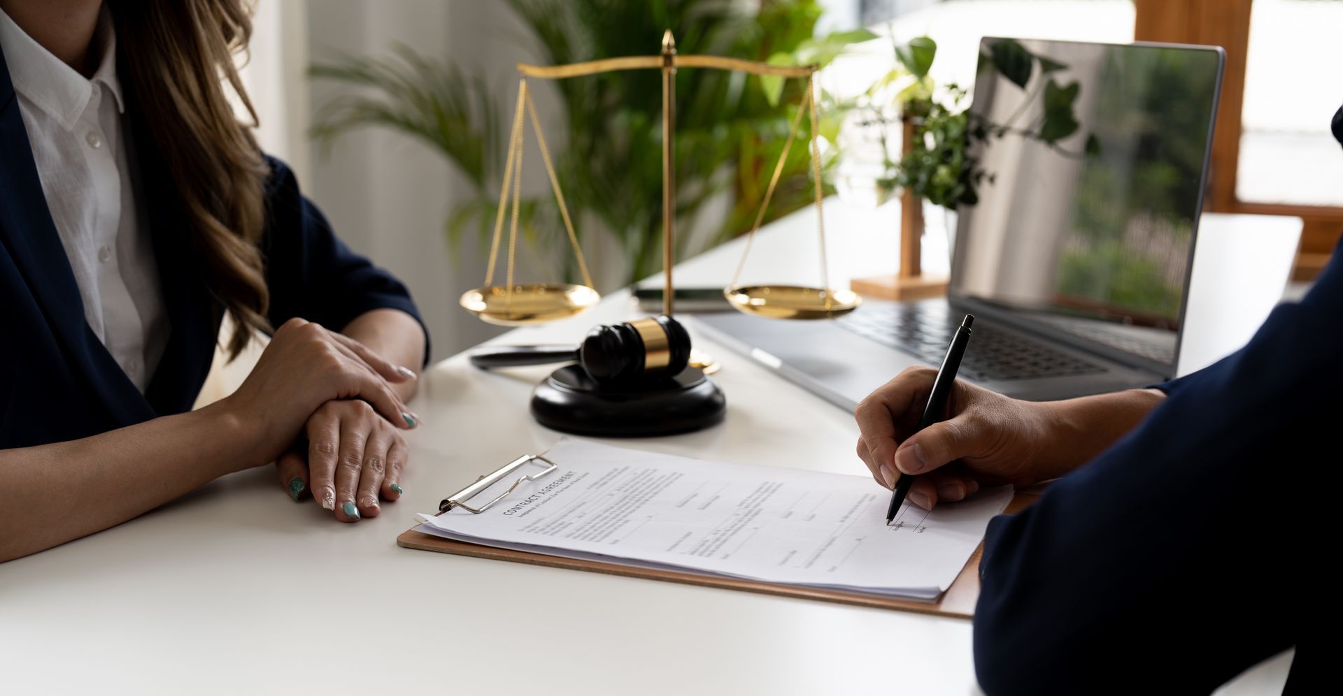 A man and a woman are sitting at a table signing a document.