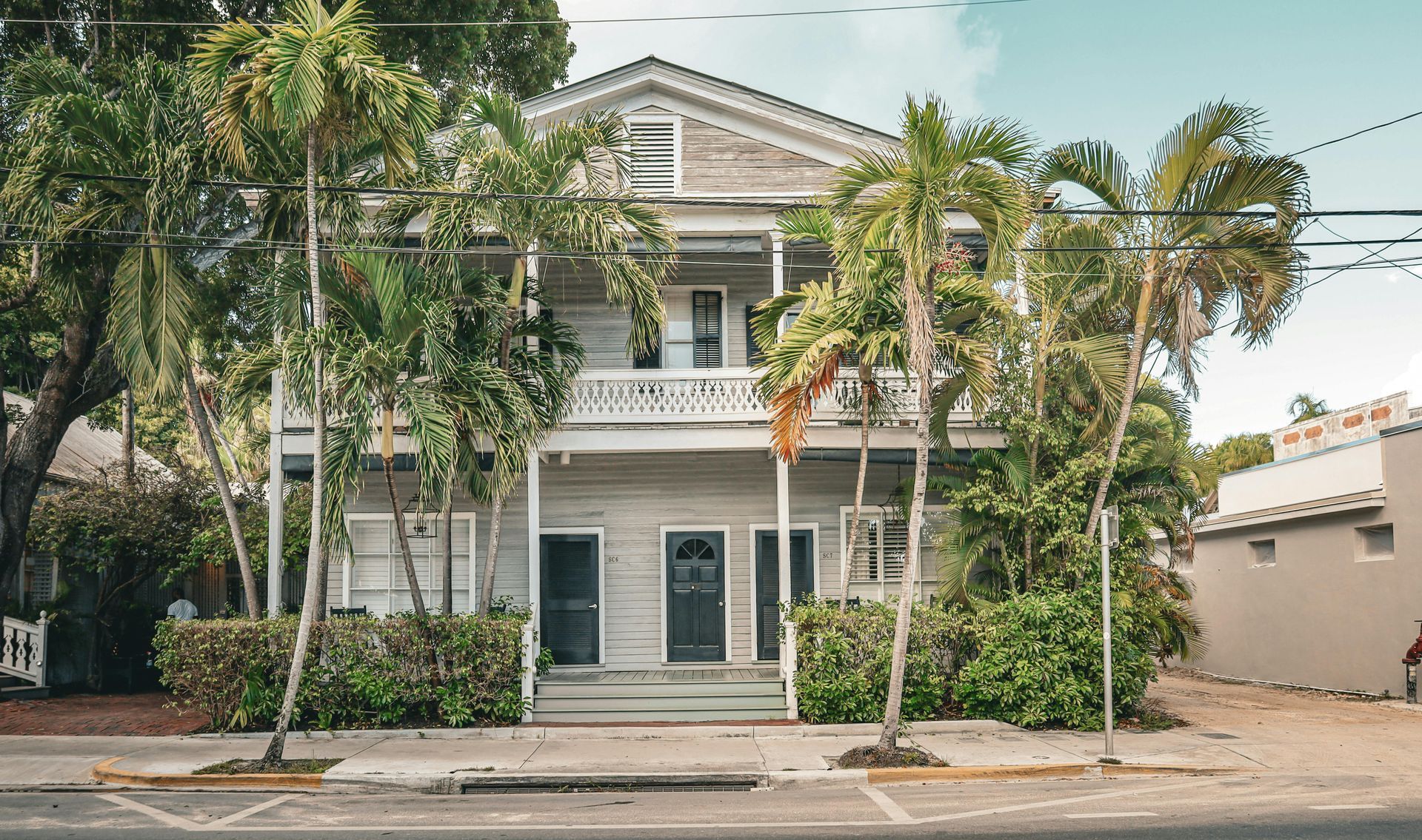 A large white house with palm trees in front of it