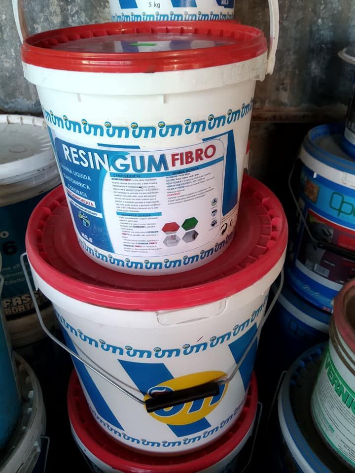 Due secchi di plastica bianca impilati con coperchi rossi e strisce blu, etichettati