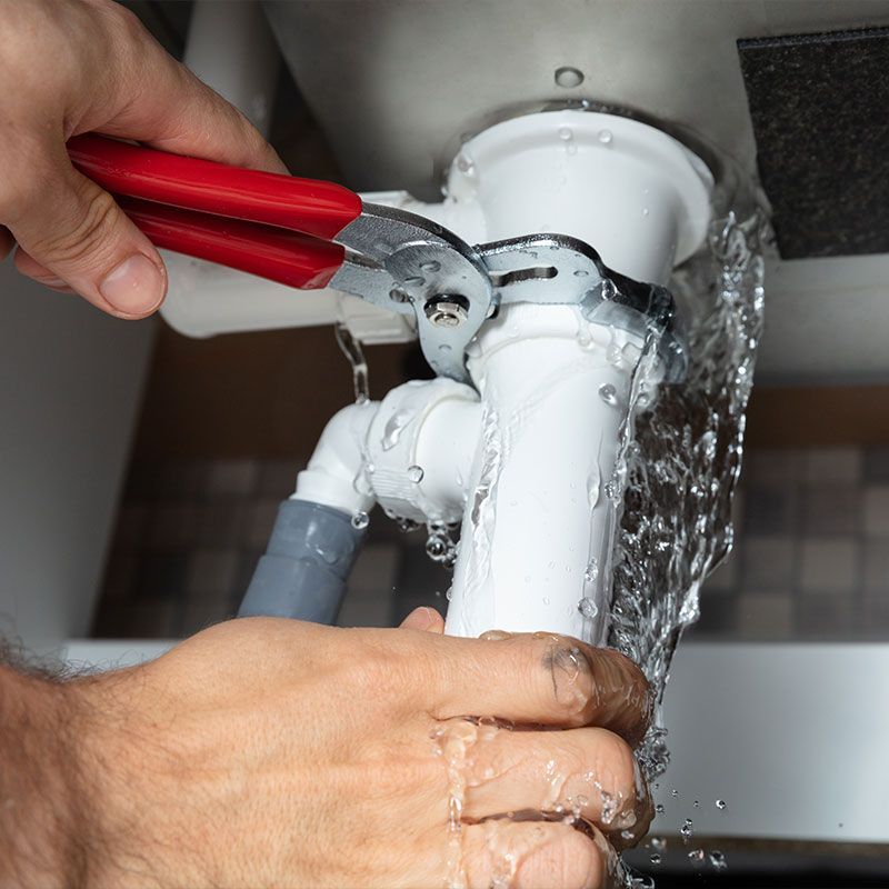 Plumber Fixing Sink Pipe With Adjustable Wrench
