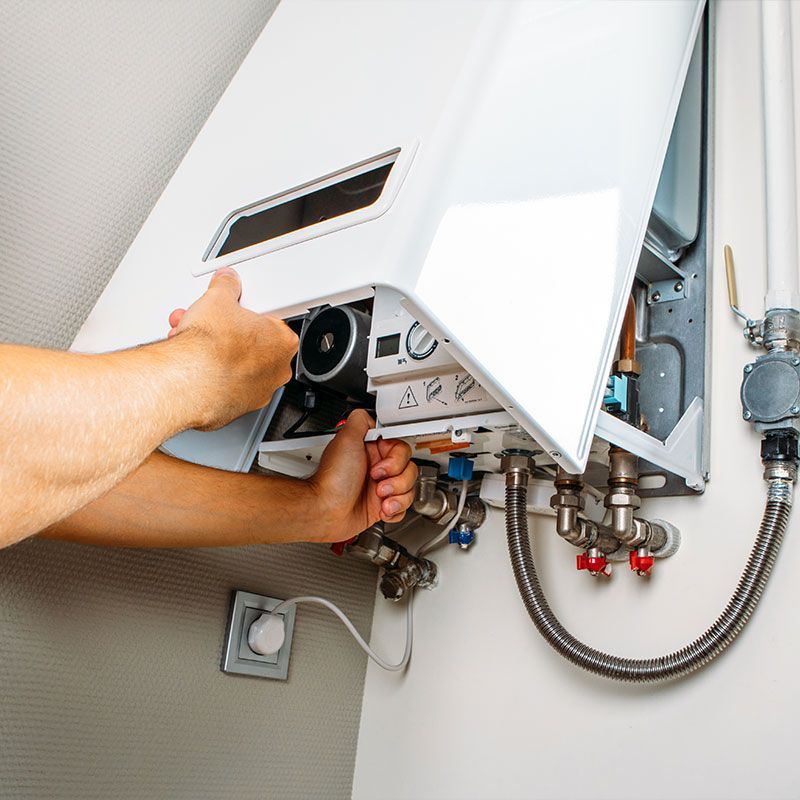 Plumber attaches Trying To Fix the Problem with the Residential Heating Equipment. Repair of a gas boiler
