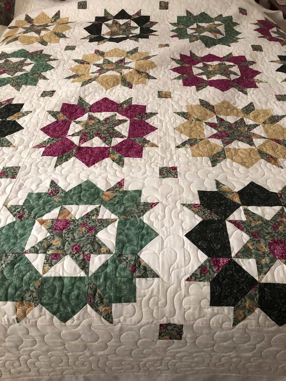 Quilt With Alternating Floral Star Blocks in Jewel Tones on a White Background — Morning Star Quilting in Bateau Bay, NSW