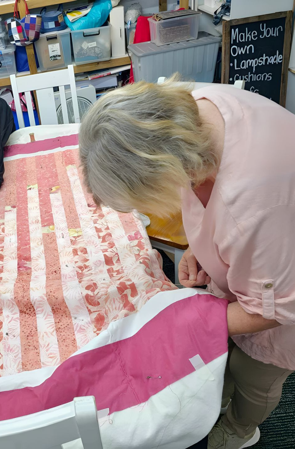 Woman Working on a Pink and White Fabric on a Table in a Workshop — Morning Star Quilting in Bateau Bay, NSW