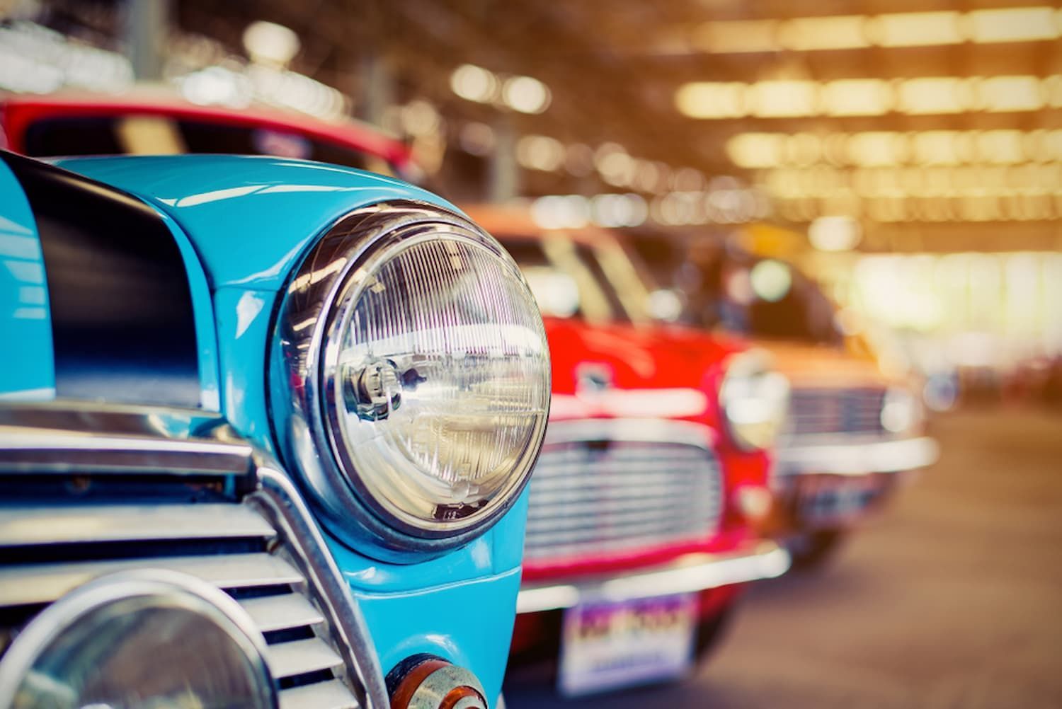 A Row of Old Cars Are Parked Next to Each Other in A Garage — Chinderah Smash Repairs in Chinderah, NSW