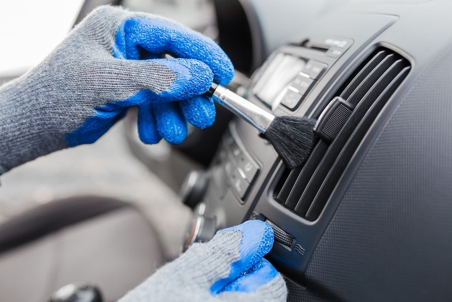 A Person Is Cleaning the Air Vents of A Car with A Brush — Chinderah Smash Repairs in Chinderah, NSW