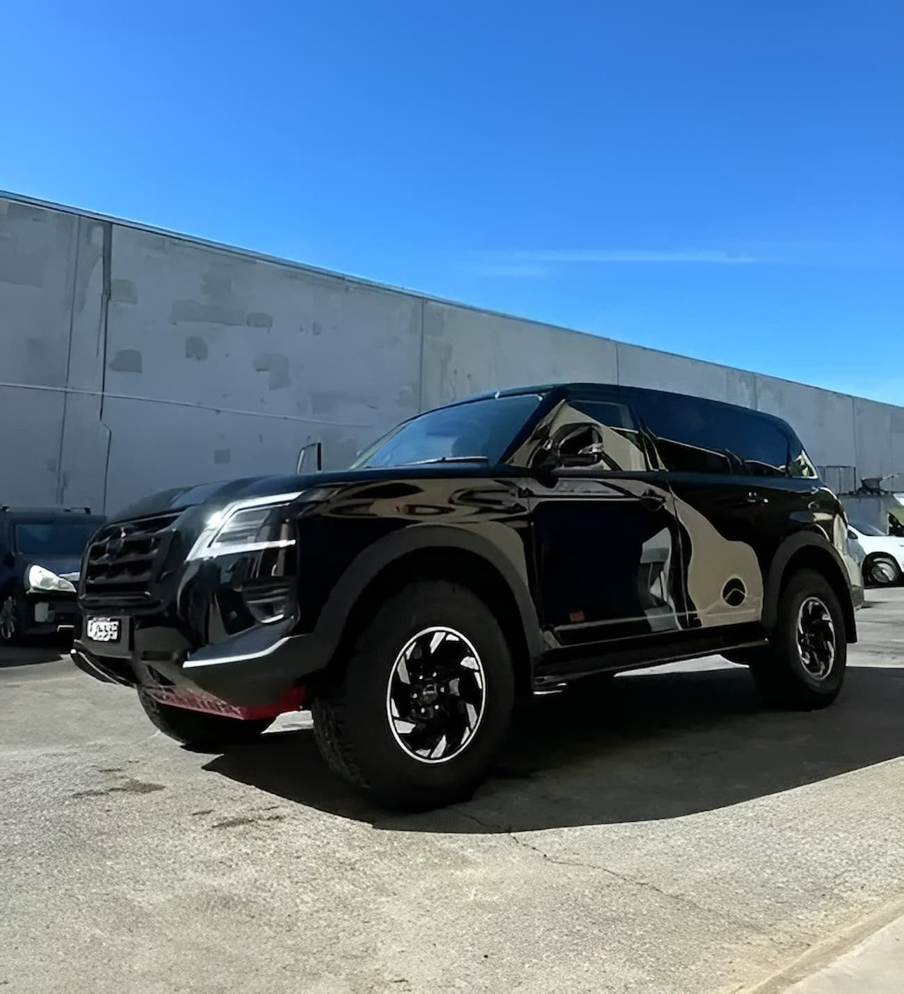 A Black SUV Is Parked in A Parking Lot in Front of A Building — Chinderah Smash Repairs in Chinderah, NSW