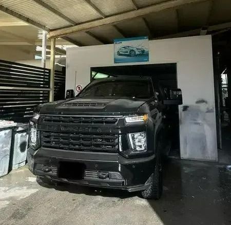 A Black Truck Is Parked in A Garage Under a Roof — Chinderah Smash Repairs in Chinderah, NSW