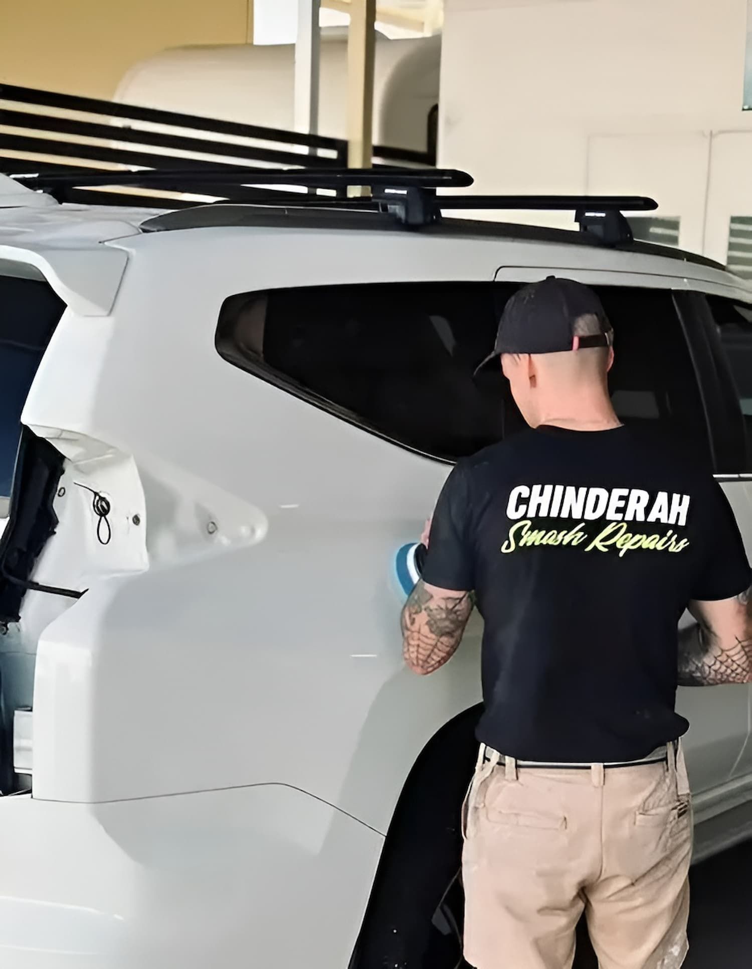 A Man Wearing a Black Shirt that Says Chinderah on It — Chinderah Smash Repairs in Chinderah, NSW