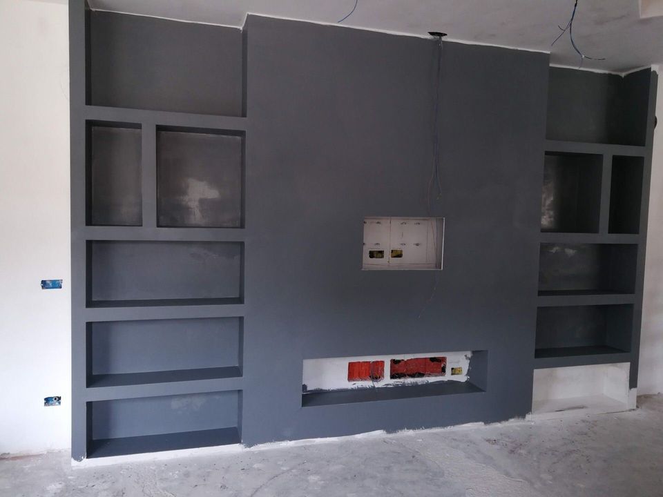 Mobile a muro integrato di colore grigio scuro con ripiani a giorno e pannello centrale incassato