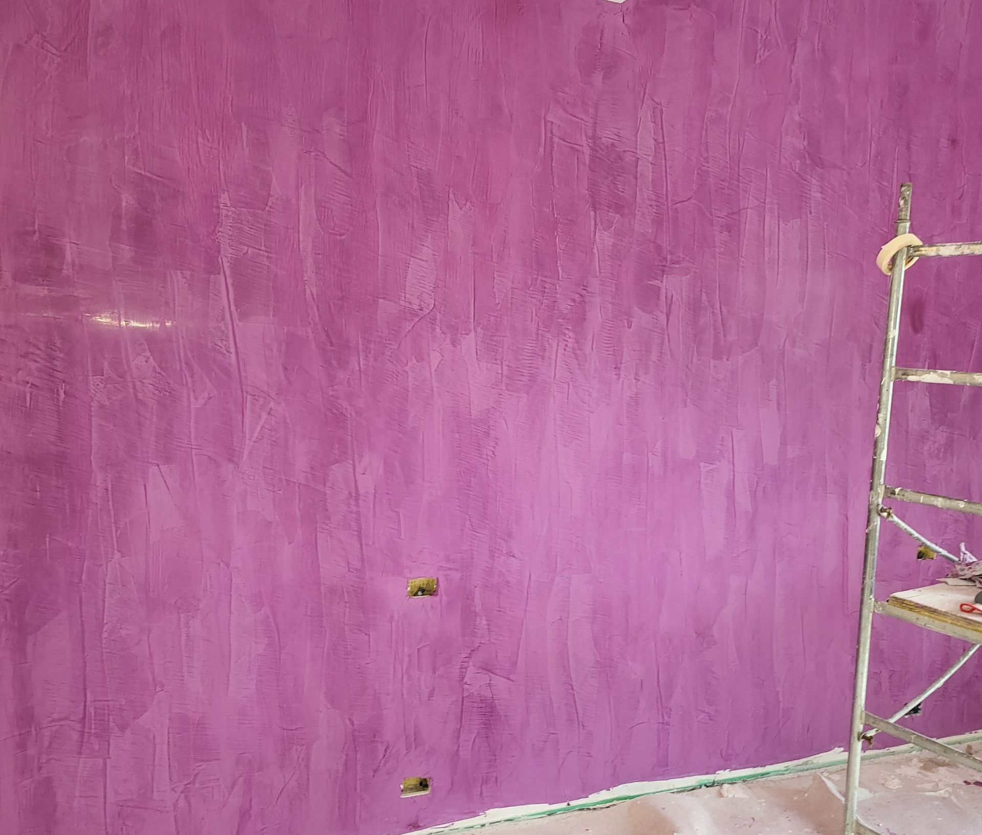 Cucina e zona pranzo moderne a pianta aperta con pavimento in legno chiaro, mobili bianchi e sedie blu.