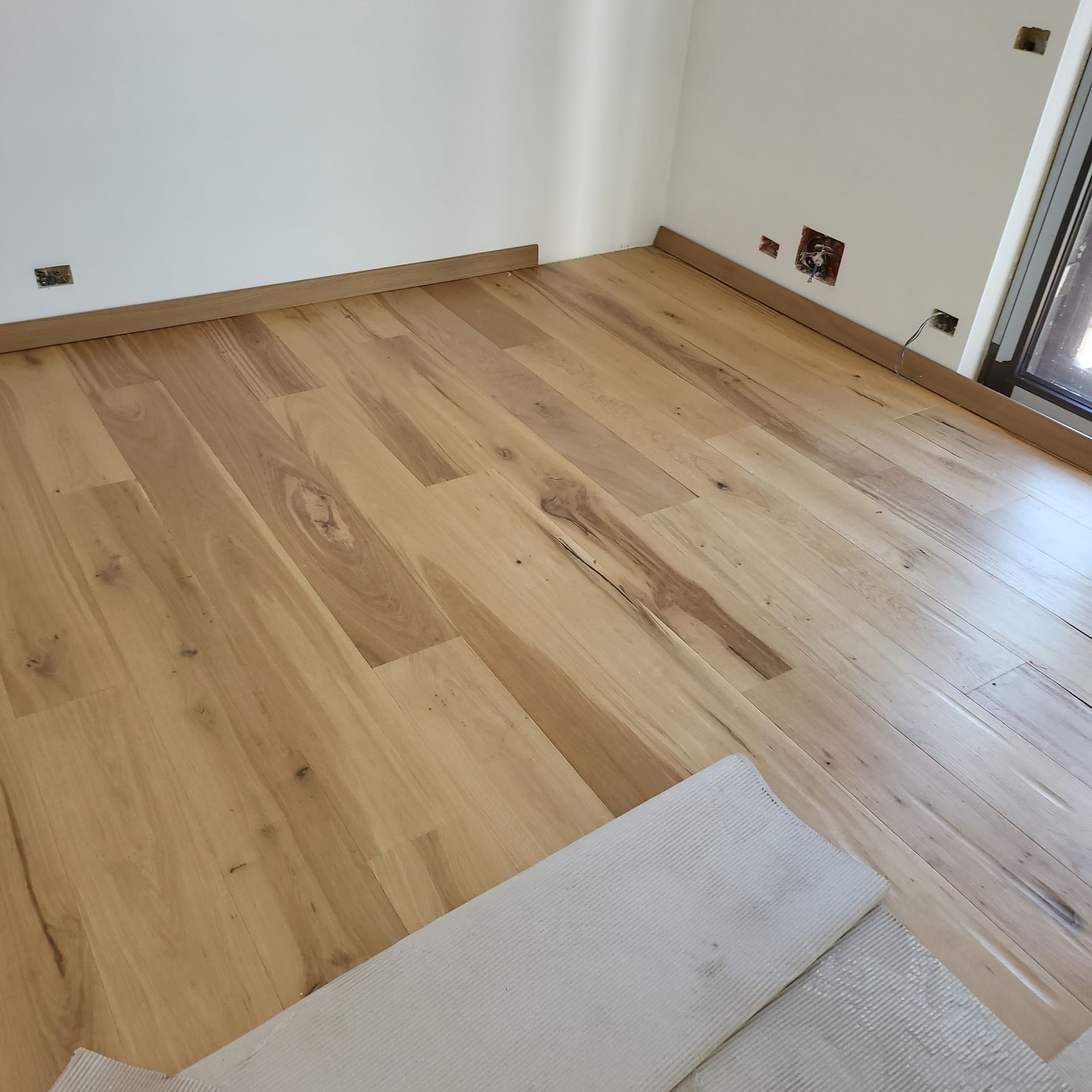 Primo piano di un pavimento in legno dalle tonalità calde con venature ben visibili e assi disposte in diagonale.