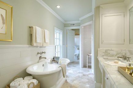 Elegant bathroom with a clawfoot tub, white tile, marble countertop, and towels.