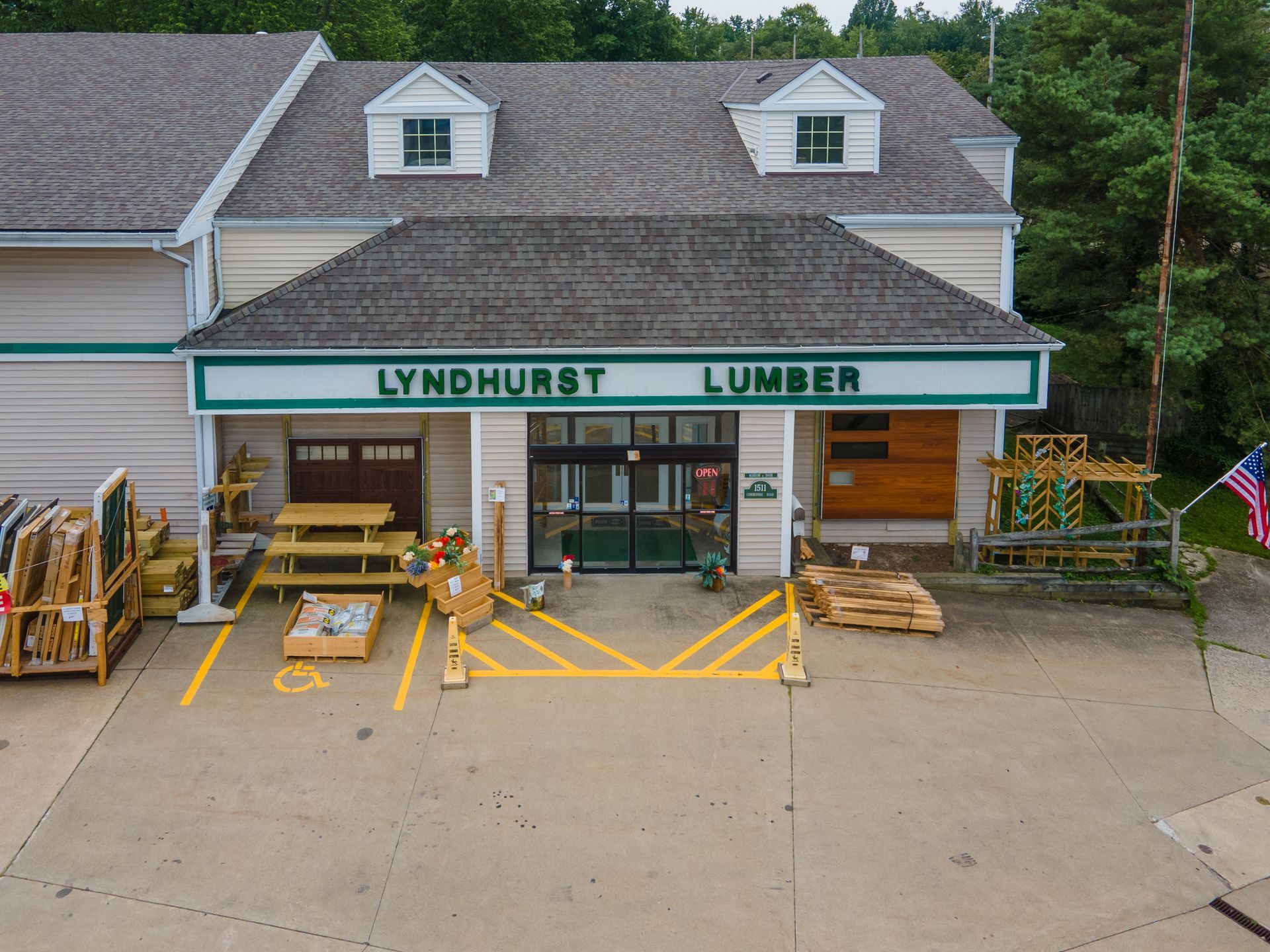 Lyndhurst Lumber storefront with tan siding, brown roof, and sign. Pallets and materials are visible outside.