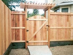 Wooden gate with pergola entrance in a cedar fence.