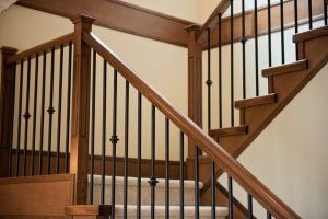Wooden staircase with black metal railings.