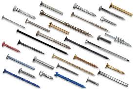Assorted screws of various sizes, shapes, and colors arranged on a white surface.