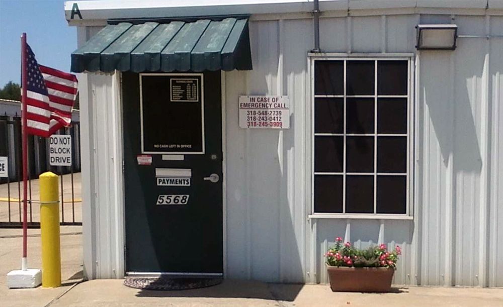 A white building with a green door and an american flag. A white building with a green door and an american flag