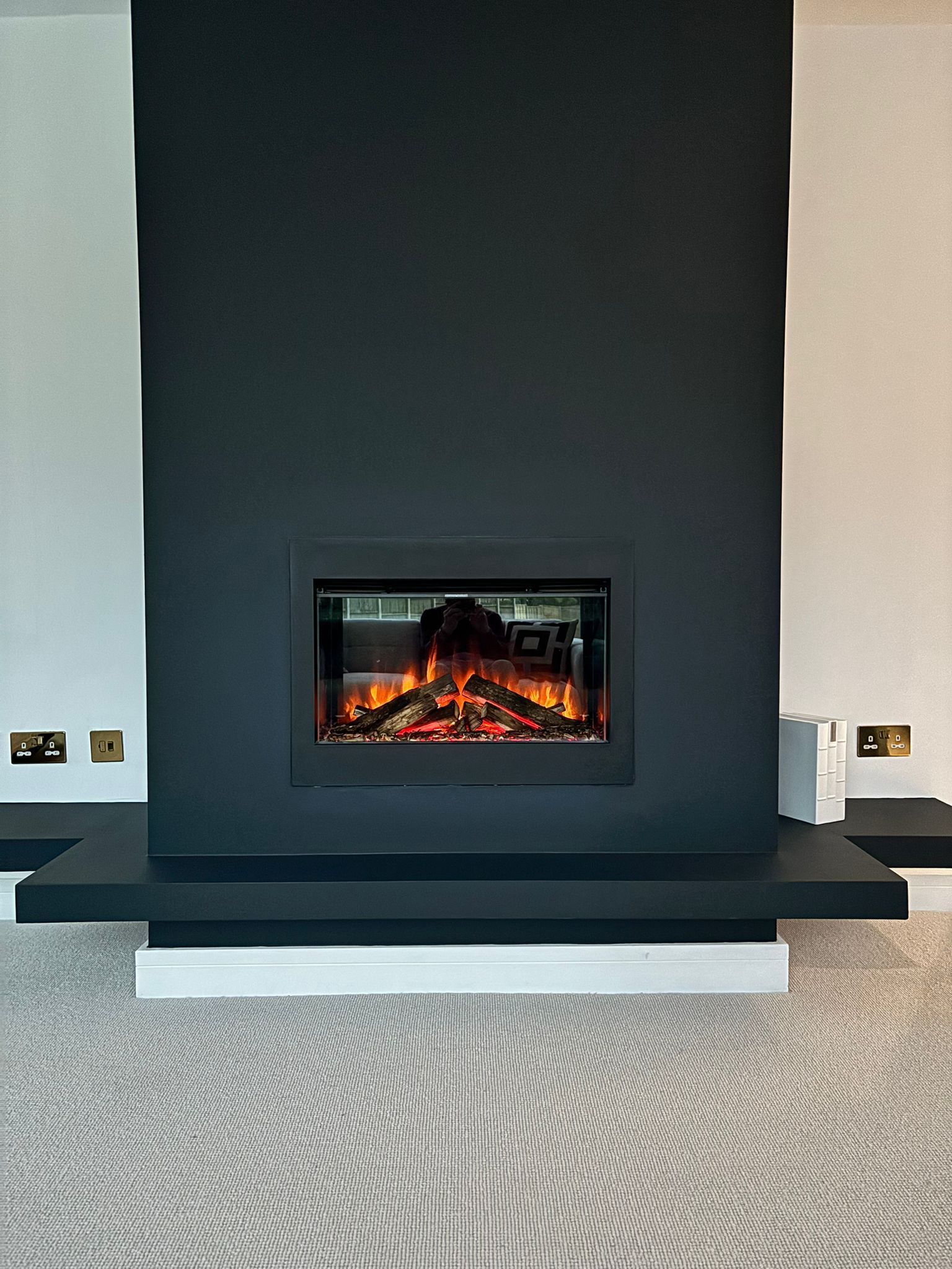 small electric fire in a flase chimney breast. In a deep modern blue colour