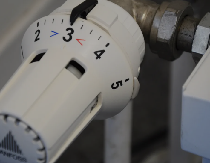 Primo piano di una manopola del termostato del radiatore bianco impostata intorno a 3