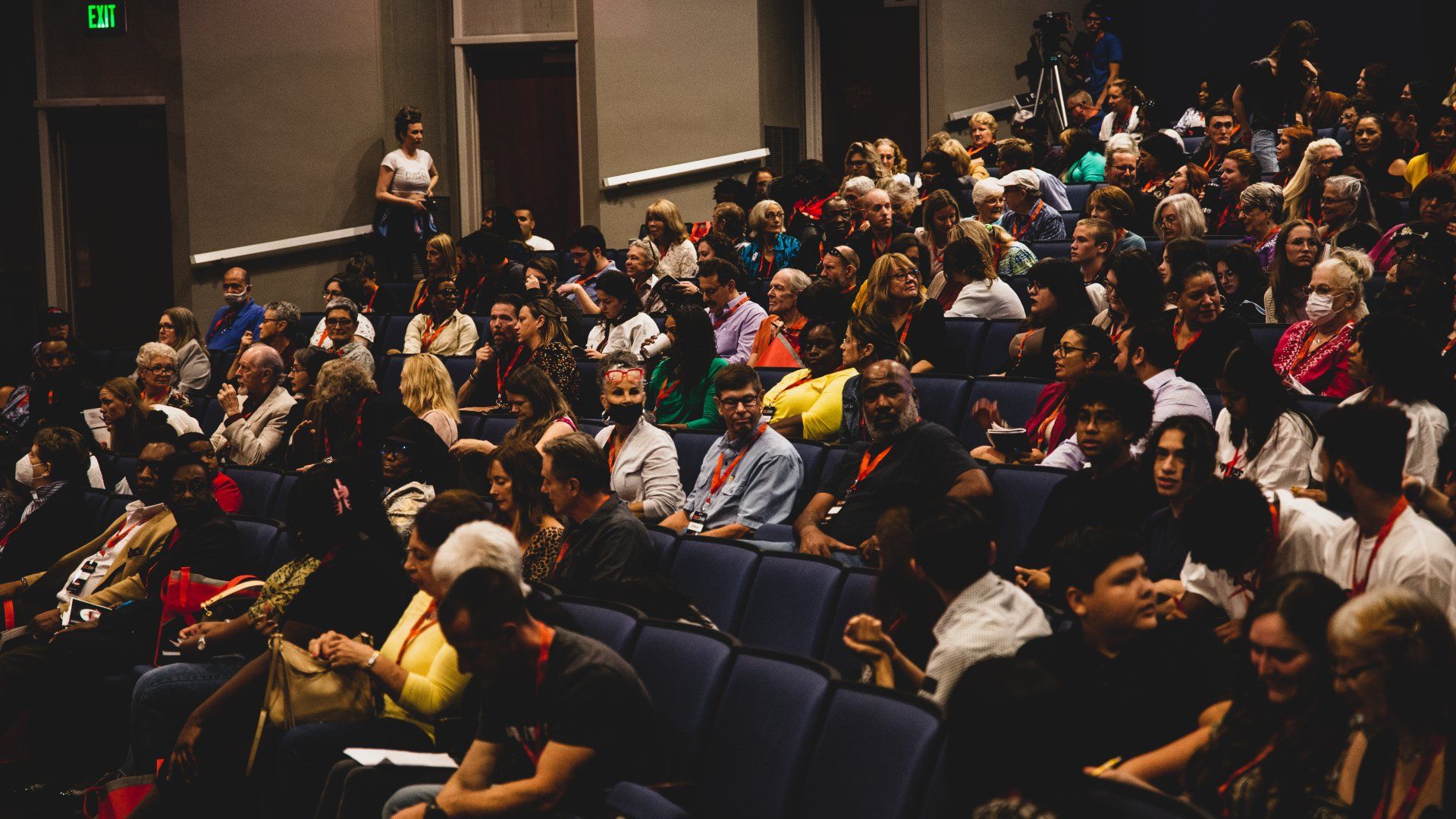 A large group of people are sitting in an auditorium.