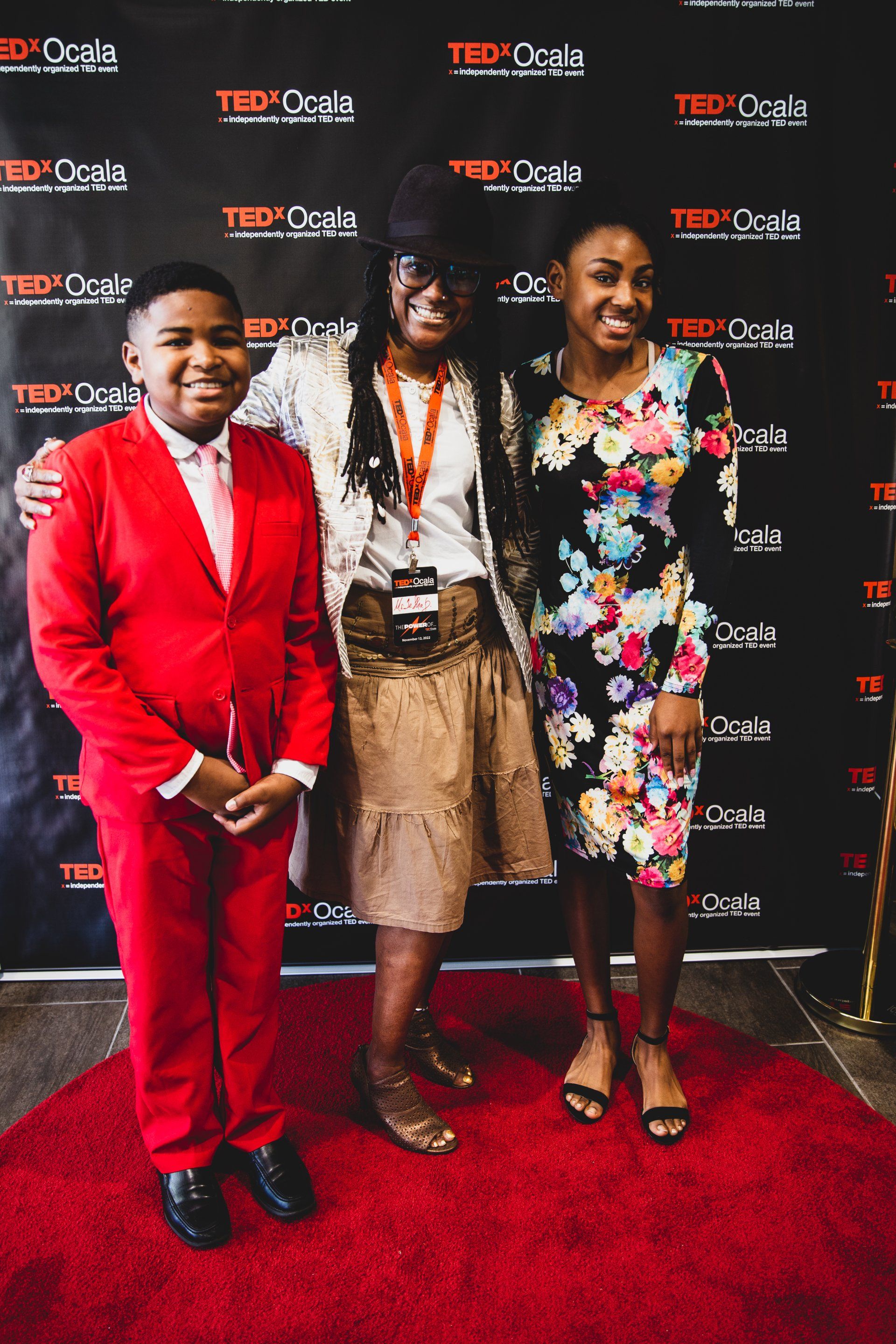 A group of people are posing for a picture on a red carpet.