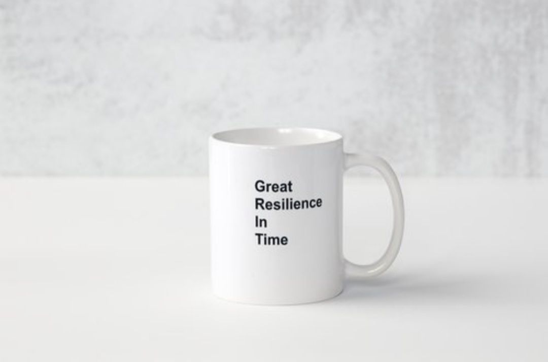 A white coffee mug with the words `` great resilience in time '' written on it.