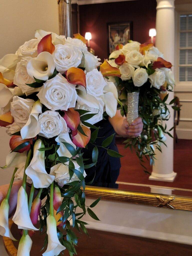 A woman is holding a bouquet of flowers in front of a mirror.