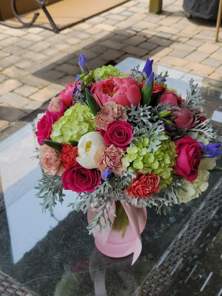 A vase filled with flowers is sitting on a glass table.