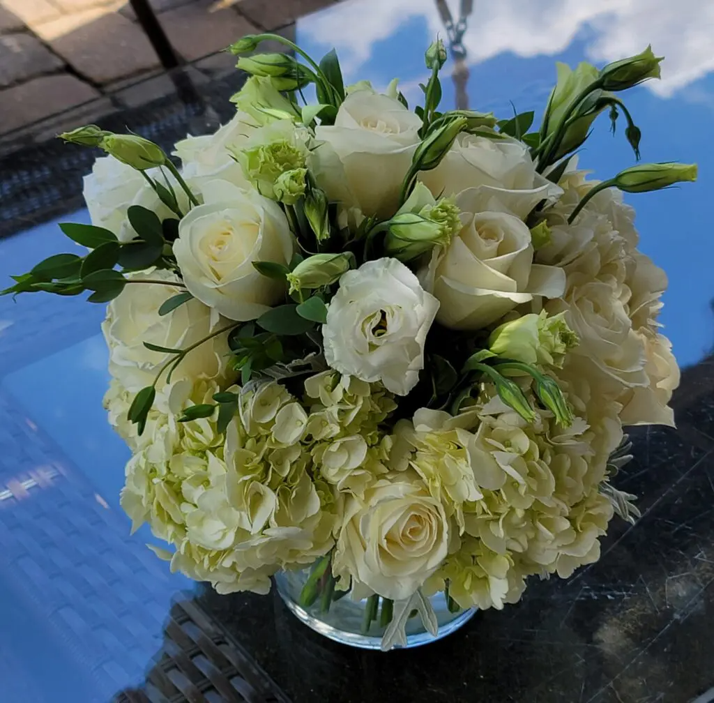 A vase filled with white flowers sits on a table