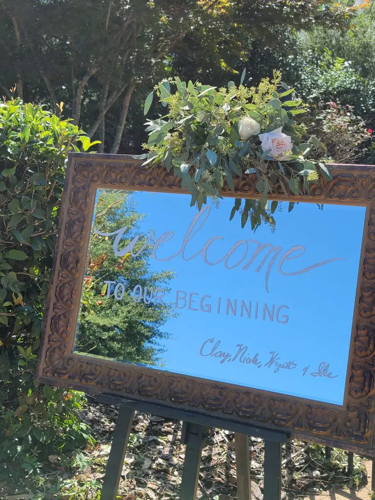 A large mirror with a welcome sign on it is sitting on an easel.